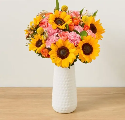 A vibrant mix of lavender alstroemeria, yellow sunflower, and pink and peach roses.