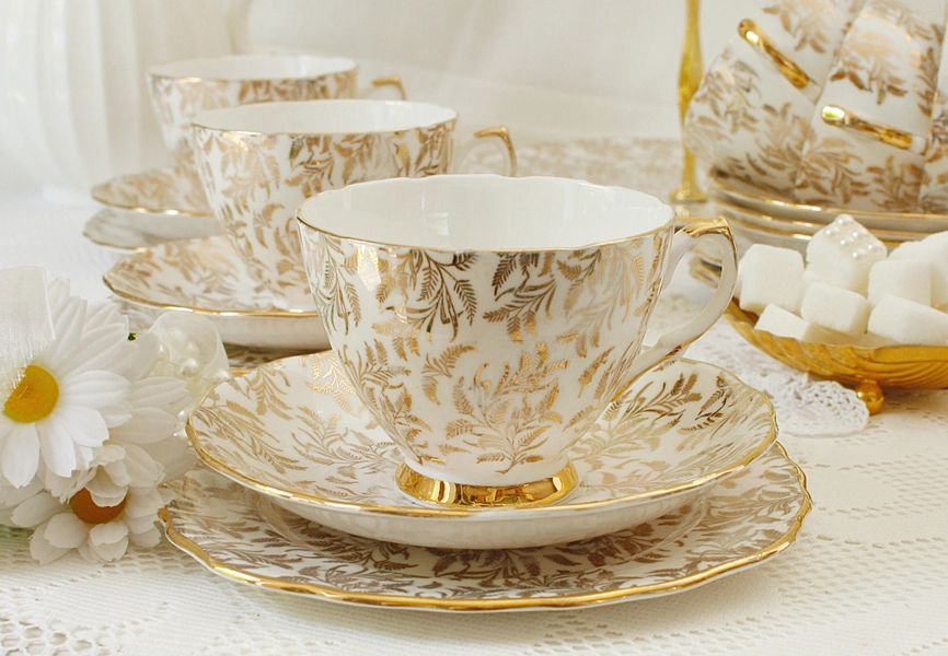 Gold and white English tea set: Crown Regent  bone china tea set with gold filigree detailing, 1 cup, 1 saucer and 1 plate.