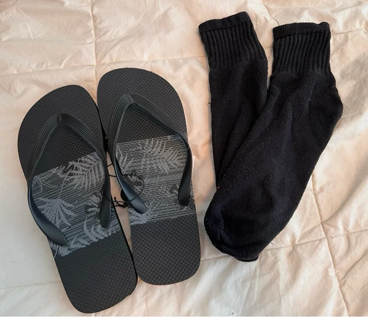 Black flip flops and black sock